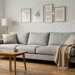 Canapé gris clair style scandinave dans un salon Airbnb moderne avec parquet en chêne et coussins moelleux