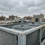 Dry cooler industriel installé sur un toit plat avec échangeurs à ailettes en aluminium et ventilateurs axiaux